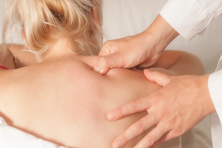 Woman lying on massage table in quiet room with candles and soft lighting