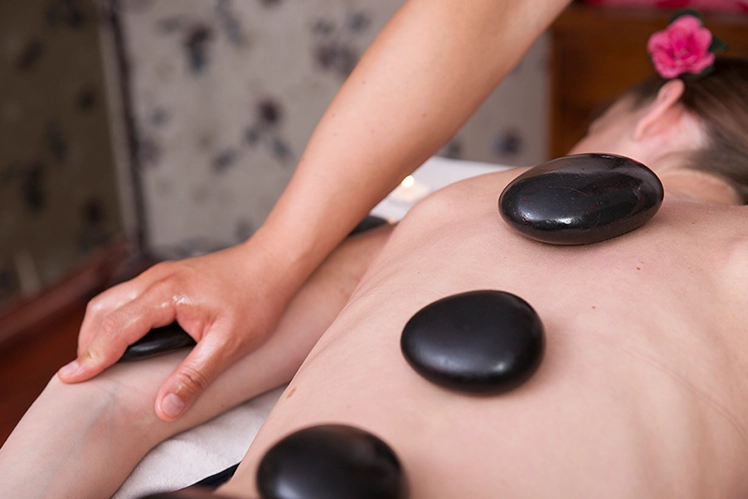 Hot Stone Massage in Progress on Relaxed Person's Back