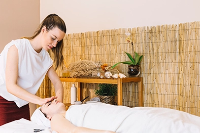 Therapist stretching client’s leg while they lie relaxed on padded table