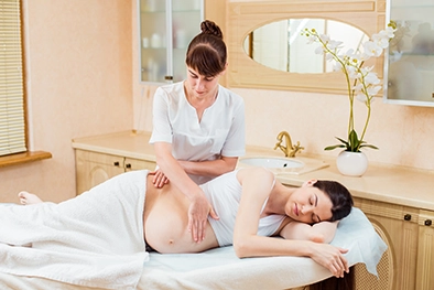 Client lying face down while therapist works on tight shoulder muscles