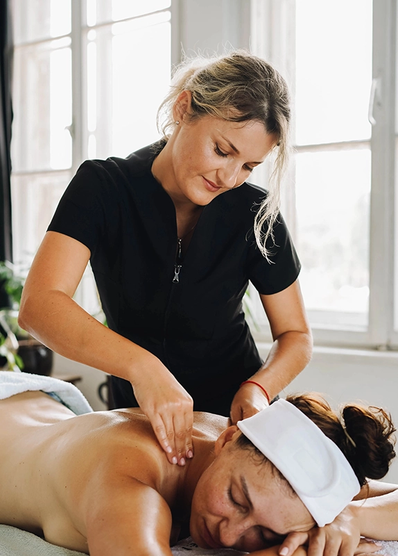 Woman Providing Swedish Massage in a Bright Room